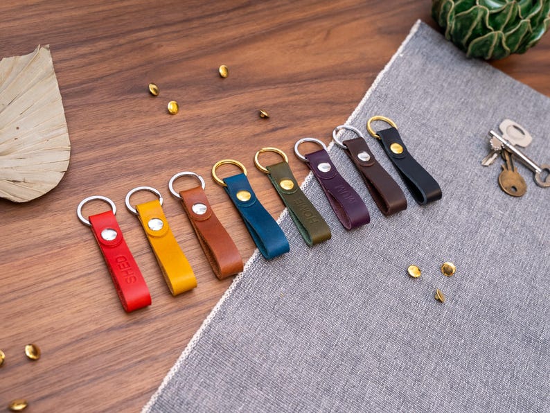 Slim Italian leather loop keyrings/keychains in multiple colours including black, brown, purple, olive green, navy blue, tan, yellow and red. Personalised with up to 6 letter debossed into the leather. Stainless steel or solid brass split ring and rivet.
