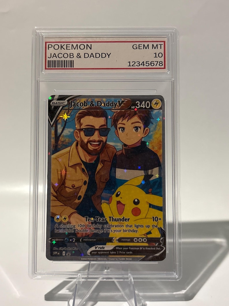 May include: A Pokemon trading card featuring "Jacob & Daddy" with a Pikachu illustration. The card is encased in a protective case, graded GEM MT 10. The card's text includes "Ten-Year Thunder" and other game-related details.