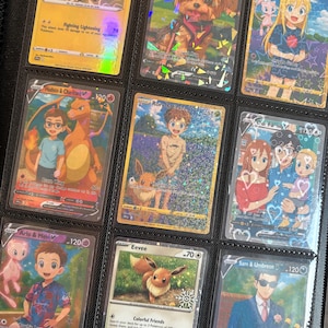 May include: A collection of Pok&eacute;mon trading cards in a binder. The cards feature various characters and illustrations, including a dog, a Charizard, and an Eevee. The cards are in protective sleeves.