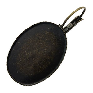 May include: Oval-shaped, antique bronze earring setting with a smooth, textured surface. The setting has a wire loop for attaching a pendant or charm.