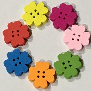 May include: Seven colorful flower-shaped buttons with four petals and three holes each. The buttons are yellow, red, pink, blue, orange, and green.