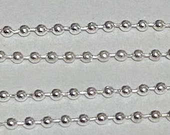 May include: A close-up of a silver ball chain necklace. The chain is made of small, round beads that are linked together.