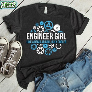 May include: Dark gray t-shirt with a blue and white design of gears and the text "Engineer Girl Like a regular girl, only cooler".