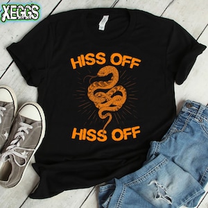 Könnte beinhalten: Schwarzes T-Shirt mit einem orangefarbenen Schlangenmotiv und dem zweimal wiederholten Text "Hiss Off".