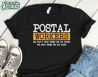 May include: Black t-shirt with white text that reads "Postal Workers" in a yellow rectangle. The text below the rectangle reads "We don't stop when we're tired. We stop when we're done."
