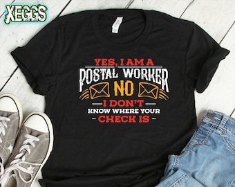 May include: Black t-shirt with a white graphic that says "Yes, I am a postal worker. No, I don't know where your check is." The graphic also includes two stylized images of envelopes.