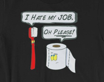 May include: Black t-shirt with a cartoon illustration of a toothbrush and a roll of toilet paper. The text "I hate my job. Oh please!" is written in a speech bubble above the toothbrush.