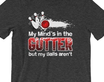 May include: Dark grey t-shirt with a white graphic of bowling pins and a bowling ball. The text "My Mind's in the Gutter but my Balls aren't" is printed in white.