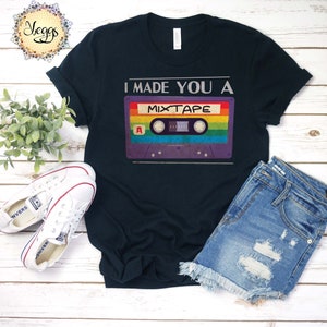 May include: A black t-shirt with the text "I made you a mixtape" and a vintage cassette tape graphic with rainbow colors.