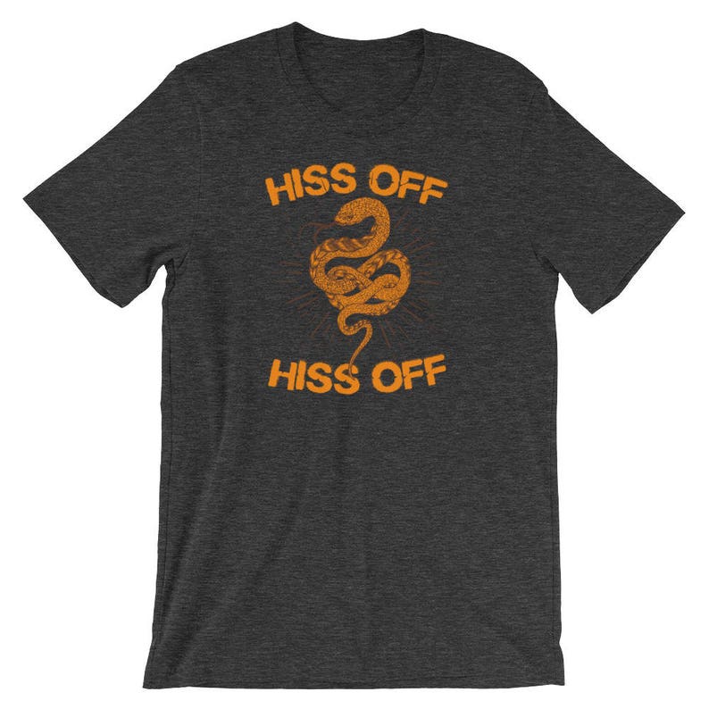 Puede incluir: Una camiseta gris oscuro jaspeada con un gr&aacute;fico de una serpiente y el texto "Hiss Off" impreso en naranja.