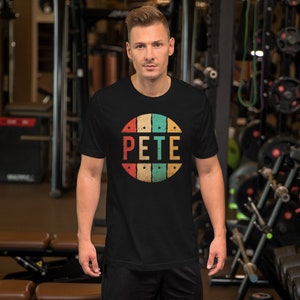 May include: A black t-shirt with a vintage-style circle graphic featuring the name "PETE" in colorful letters and stars.