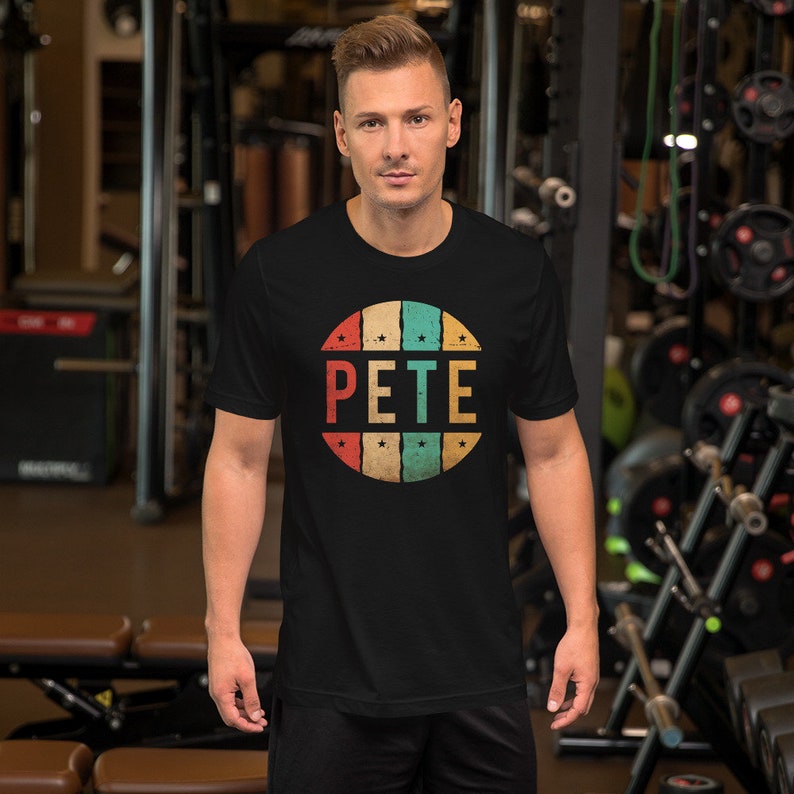 May include: A black t-shirt with a vintage-style circle graphic featuring the name "PETE" in colorful letters and stars.