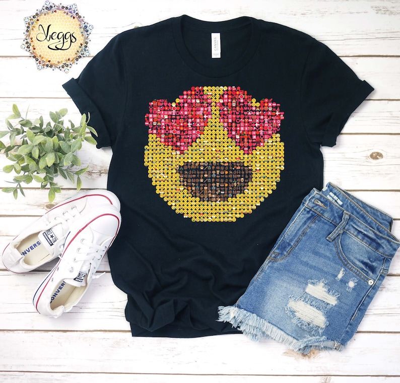 Puede incluir: Camiseta negra con un gran dise&ntilde;o de cara emoji hecho de emojis m&aacute;s peque&ntilde;os. El emoji tiene ojos en forma de coraz&oacute;n y una boca sonriente. La camiseta se muestra con pantalones cortos de mezclilla y zapatillas blancas.