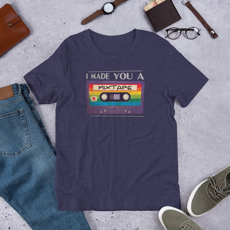 May include: A navy blue t-shirt with the text "I made you a mixtape" and a vintage cassette tape graphic with rainbow colored tape.