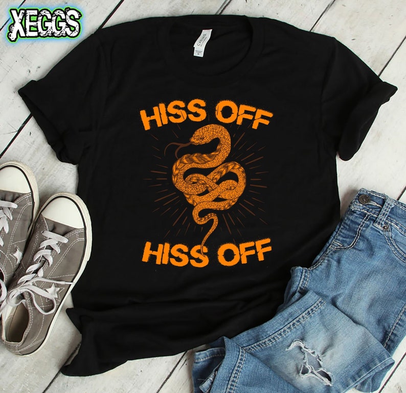 Puede incluir: Camiseta negra con un gr&aacute;fico de serpiente naranja y el texto "Hiss Off" repetido dos veces.