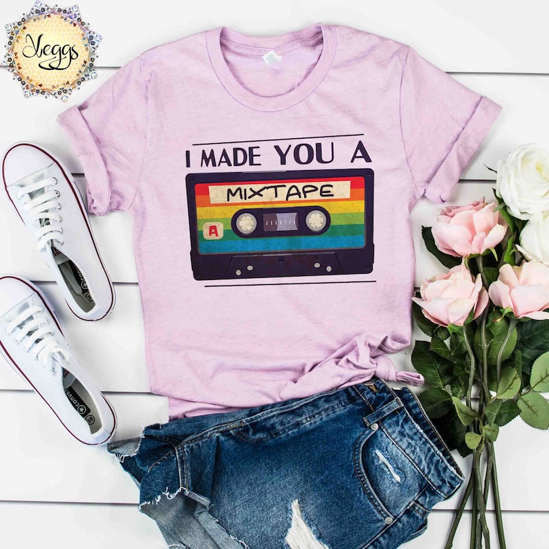 May include: A pink t-shirt with the text "I made you a mixtape" and a vintage cassette tape graphic with rainbow colors.