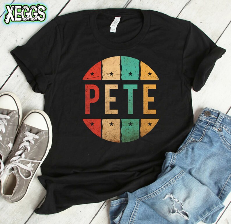 May include: Black t-shirt with a vintage-style circle graphic featuring the name "PETE" in white letters. The circle has a red, orange, yellow, green, and blue color scheme.