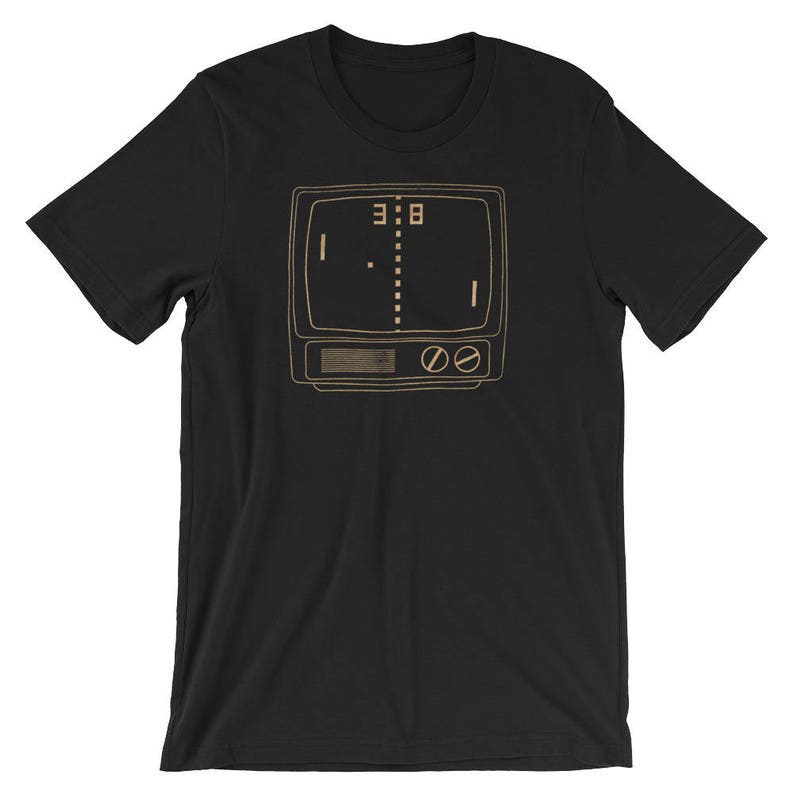 Puede incluir: Camiseta negra con una ilustraci&oacute;n de estilo retro de una consola de juegos de arcade vintage con el marcador 3:8 en la pantalla.
