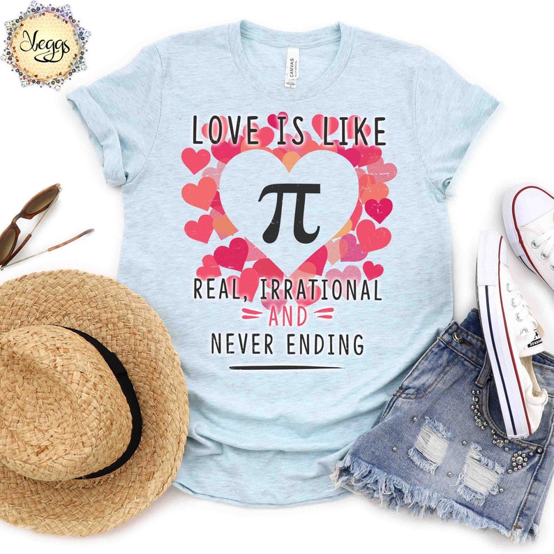 Pu&ograve; includere: Maglietta blu chiaro con una grafica di un cuore che contiene un simbolo pi. Il testo "Love is like Pi, Real, Irrational and Never Ending" &egrave; stampato sotto il cuore.