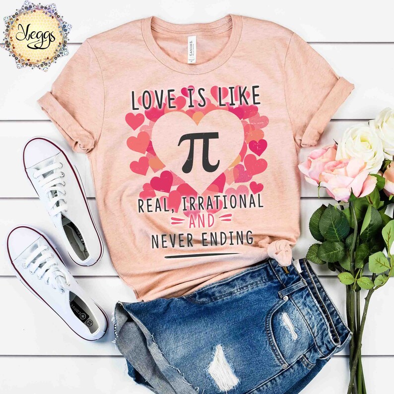 Pu&ograve; includere: Una maglietta rosa con il testo "Love is like Pi, Real, Irrational and Never Ending" con un cuore rosa che contiene il simbolo di Pi e circondato da cuori rosa pi&ugrave; piccoli.
