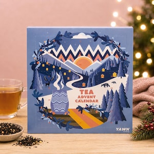 Könnte beinhalten: Ein quadratischer Tee-Adventskalender mit einer blauen Winterlandschaft, Bergen, Tannen, einem Hirsch und einer dampfenden Tasse. Der Text lautet TEA ADVENT CALENDAR und YAWN. Das Design enthält nummerierte, perforierte Türchen.