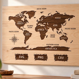 May include: A rectangular light-colored wooden wall plaque featuring a dark brown laser-cut world map. The map includes labels for continents and oceans, a compass rose, and the text SVG, PNG, and CRV at the bottom.