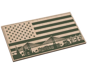 May include: A wooden plaque with a green silhouette of the Charleston, South Carolina skyline, including the Cooper River bridges, against a background of the American flag.