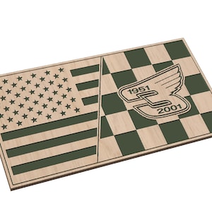 Peut inclure: Une plaque en bois avec un motif en damier vert, blanc et noir sur le côté droit. Le motif en damier présente un logo ailé stylisé avec le texte "1951" et "2001". Le côté gauche de la plaque présente un motif de drapeau américain vert et blanc.