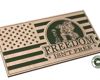 May include: A wooden sign with a green American flag design and the text "FREEDOM ISN'T FREE". The sign features a silhouette of a soldier kneeling with a rifle and a poppy.