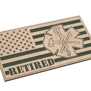 Könnte beinhalten: Ein Holzschild mit einem amerikanischen Flaggenmuster und einem grünen medizinischen Symbol mit einer gekreuzten Axt und Schlange. Das Schild trägt die Aufschrift "RETIRED" in grünen Buchstaben.