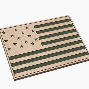 Puede incluir: Una bandera americana de madera con un acabado verde desgastado. La bandera está hecha de madera y tiene un diseño en relieve. Las estrellas están cortadas en la madera y las rayas están pintadas de verde.