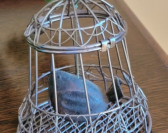 Cute little bird-shaped bell in a birdcage