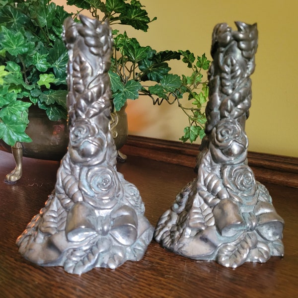Vintage well-worn, silver-tone pair of metal candlestick holders.