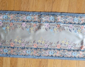 Beautiful vintage table runner features embroidered flowers.