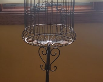 Vintage metal decorative bird cage on a stand.