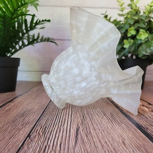 May include: A white glass lampshade with a textured, speckled finish. The lampshade is shaped like a fish with a wide, open mouth.