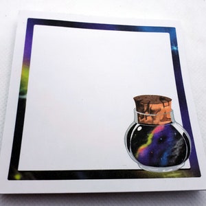Può includere: Una carta bianca con un bordo nero che presenta un'illustrazione di una bottiglia di vetro con un tappo di sughero a tema galattico. La bottiglia è piena di una galassia vorticosa di colori viola, blu e arancio.