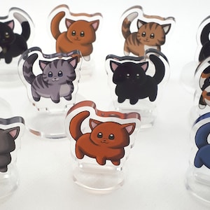 Op de afbeelding: Set van tien acryl kattenfiguren. De katten staan in verschillende poses en hebben verschillende vachtkleuren, waaronder zwart, wit, oranje, grijs, bruin en calico.