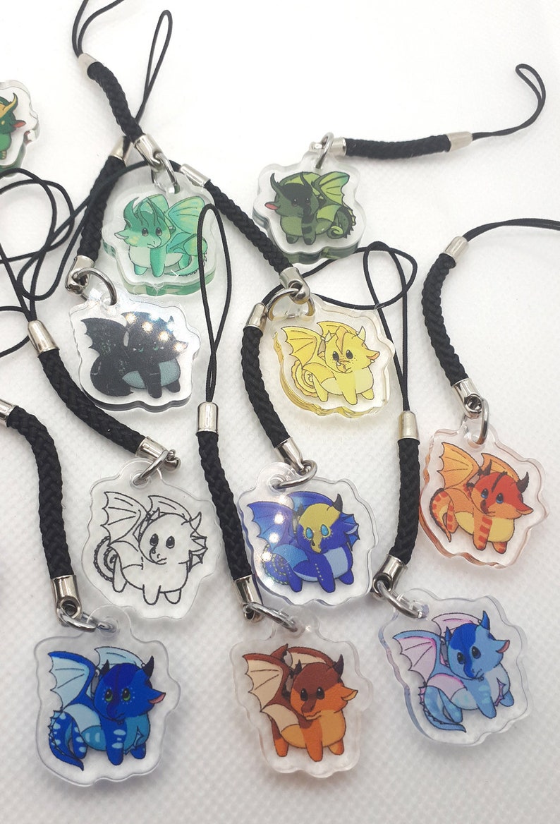 May include: A set of ten colorful dragon charm keychains. Each keychain features a pair of dragons in a clear plastic charm with a black cord.