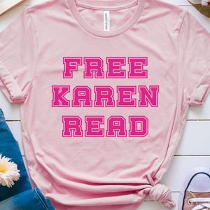 Puede incluir: Camiseta rosa con el texto "FREE KAREN READ" en letras mayúsculas rosas.