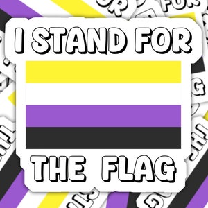 May include: A sticker with the text "I stand for the flag" and a graphic of the non-binary pride flag, which is yellow, purple, and black.