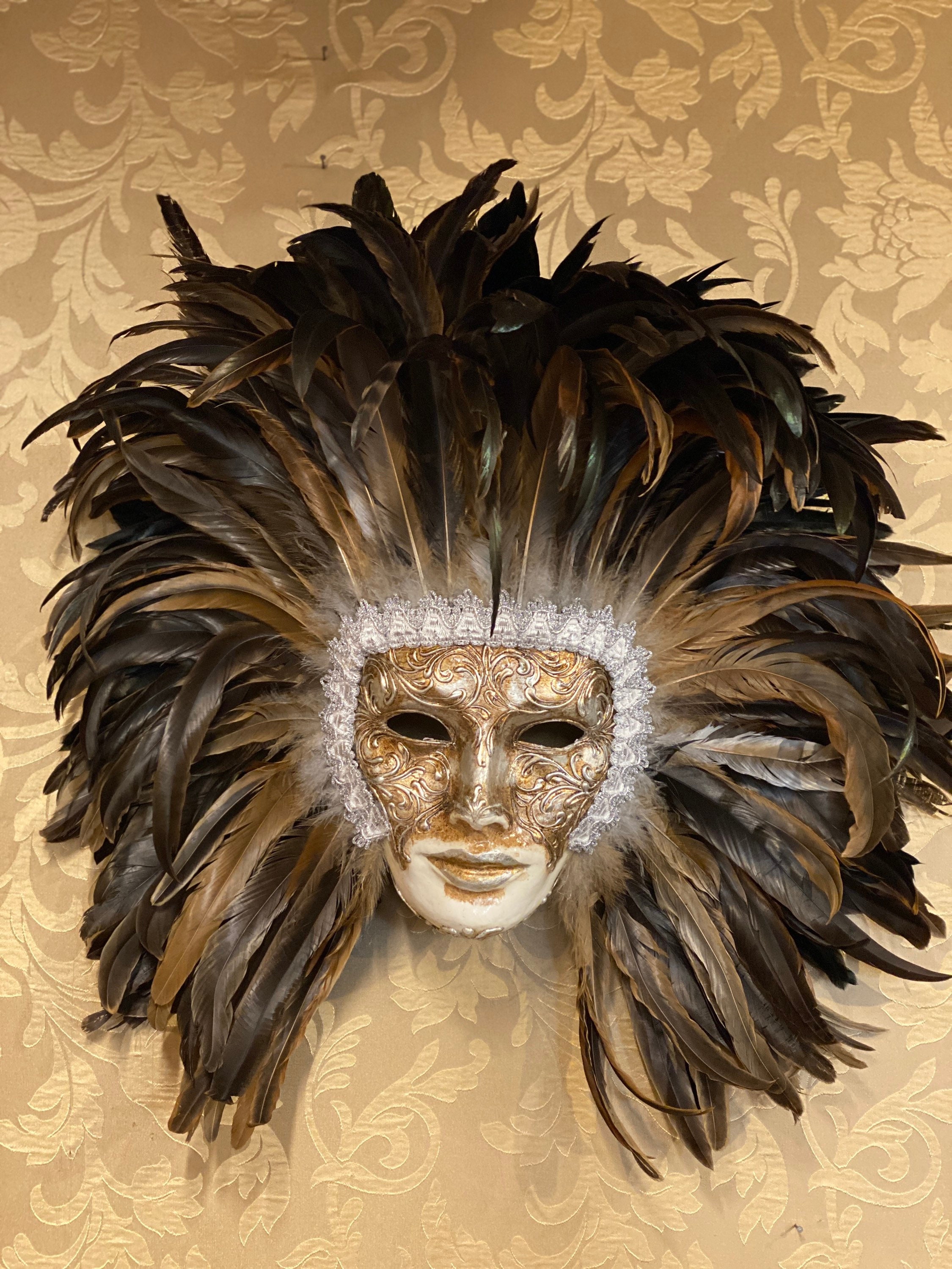 A woman in a feather Venetian mask poses during the Venice