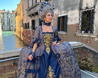 Könnte beinhalten: Eine Frau in einem blauen und goldenen Brokatkleid mit einer großen gepuderten Perücke. Sie steht auf einer Brücke in Venedig, Italien.