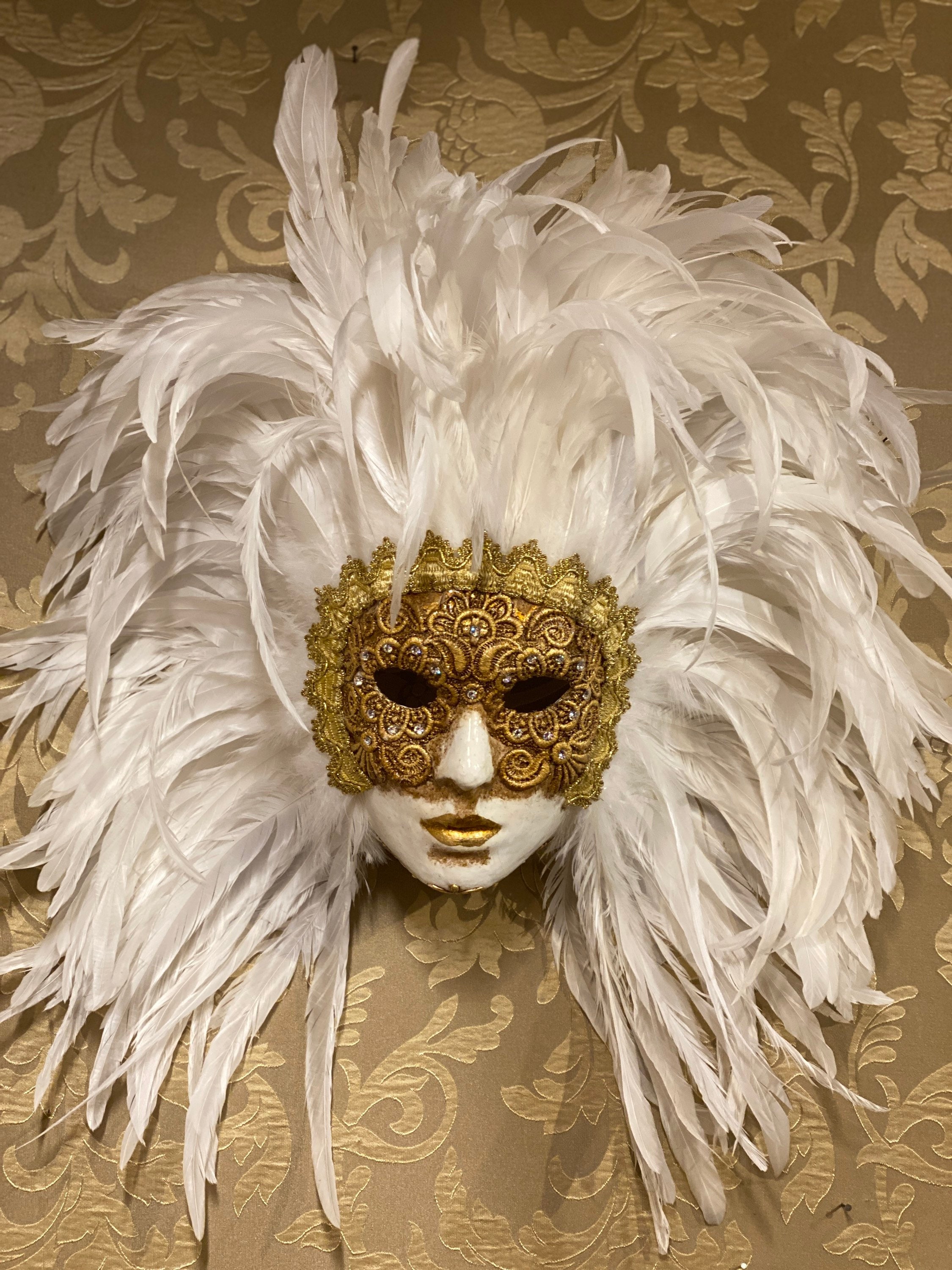 Elegant gold and white mask with feathers and crown on Craiyon