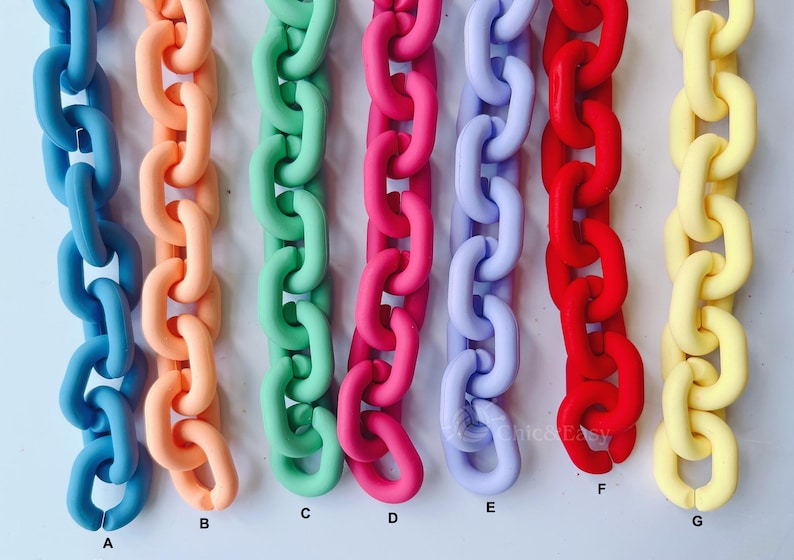 May include: A collection of colorful chain links in various shades, including blue, peach, green, pink, lavender, red, and yellow. The chains are arranged vertically, showcasing their vibrant hues and glossy finish. The image is well-lit, highlighting the smooth texture of the links.
