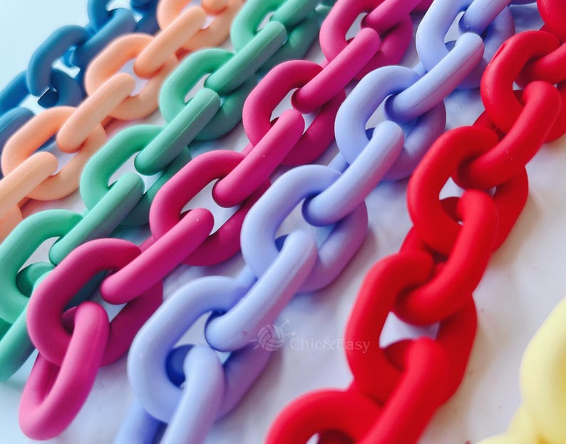 May include: Close-up of colorful plastic chain links in a variety of colors, including blue, orange, green, pink, purple, and red. The links are arranged diagonally, creating a vibrant and playful pattern. The chains are made of a matte material.