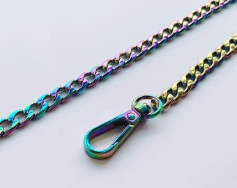 May include: Iridescent chain with a lobster clasp. The chain and clasp have a rainbow finish, displaying colors like blue, green, and gold. The chain is made of metal and has a curb link design. The clasp is attached to the chain.