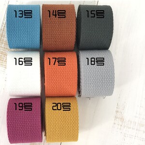 Puede incluir: Diez rollos de cinta de algod&oacute;n en varios colores, incluyendo azul, marr&oacute;n, negro, blanco, naranja, gris, morado y amarillo. Cada rollo est&aacute; etiquetado con un n&uacute;mero en coreano.