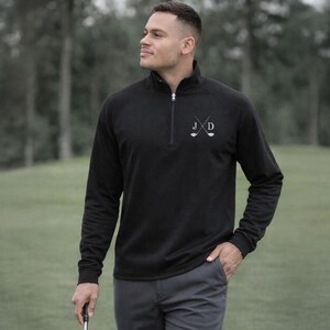 Golfer Wearing Black Quarter Zip Pullover Sweatshirt with Embroidered Initials on the golf course later in the day