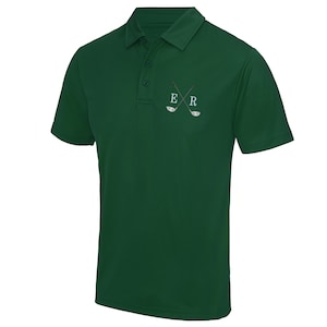 May include: A dark green polo shirt with a white embroidered design of crossed golf clubs and the letters "ER".